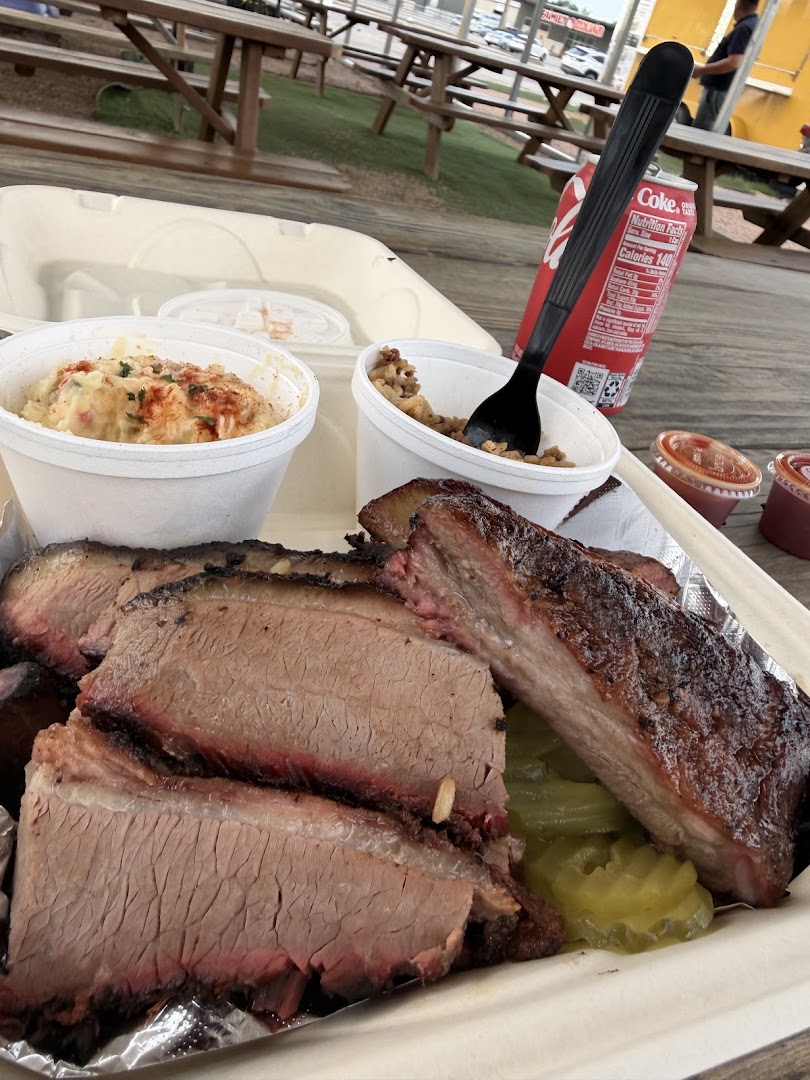 Barbecue combo tray holding sliced brisket, pork ribs and two sides