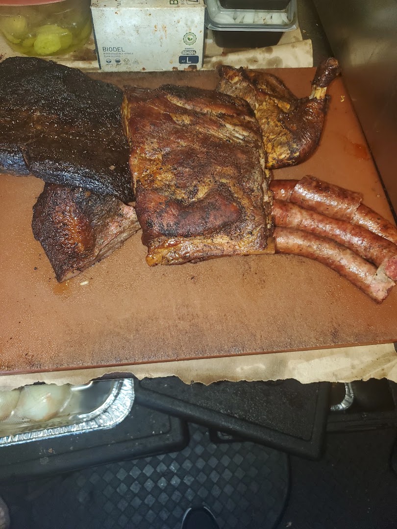 Whole smoked brisket, ribs, chicken and sausage links laid out together